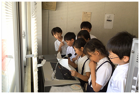 環境問題について学んだことを校内放送で話している様子